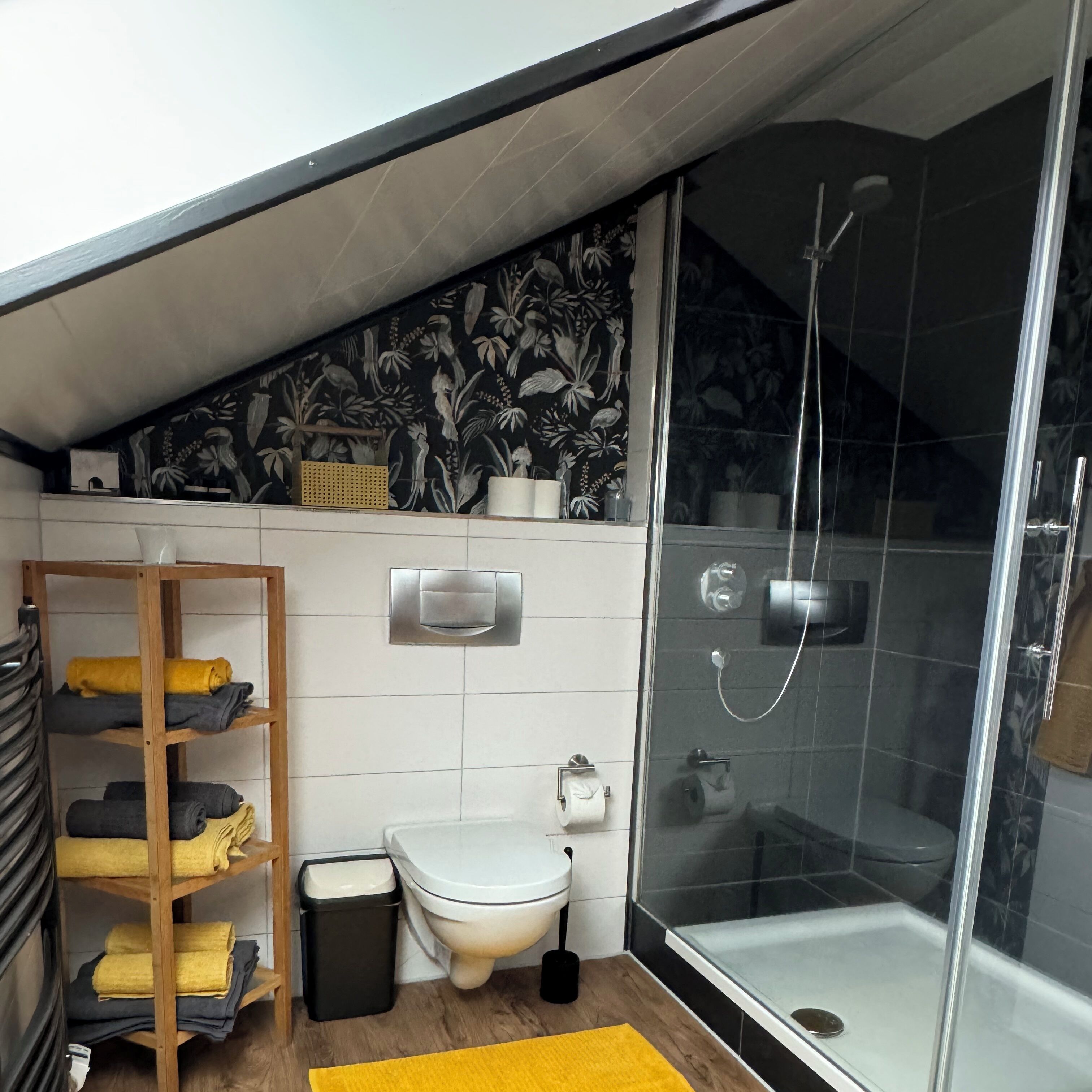 Un baño moderno con ducha, inodoro y toallero.