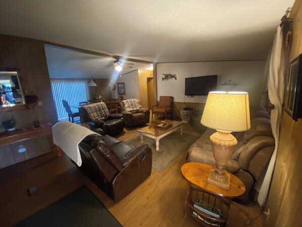 A cozy living room with leather sofas, a coffee table, and a lamp. - 2,000 sq ft 3bedroom with WiFi, AC, large screen porch overlooking Lake George. (Georgetown)