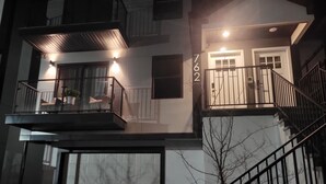 Un immeuble à plusieurs étages, doté de balcons, avec le numéro de porte 762 bien visible et un escalier.