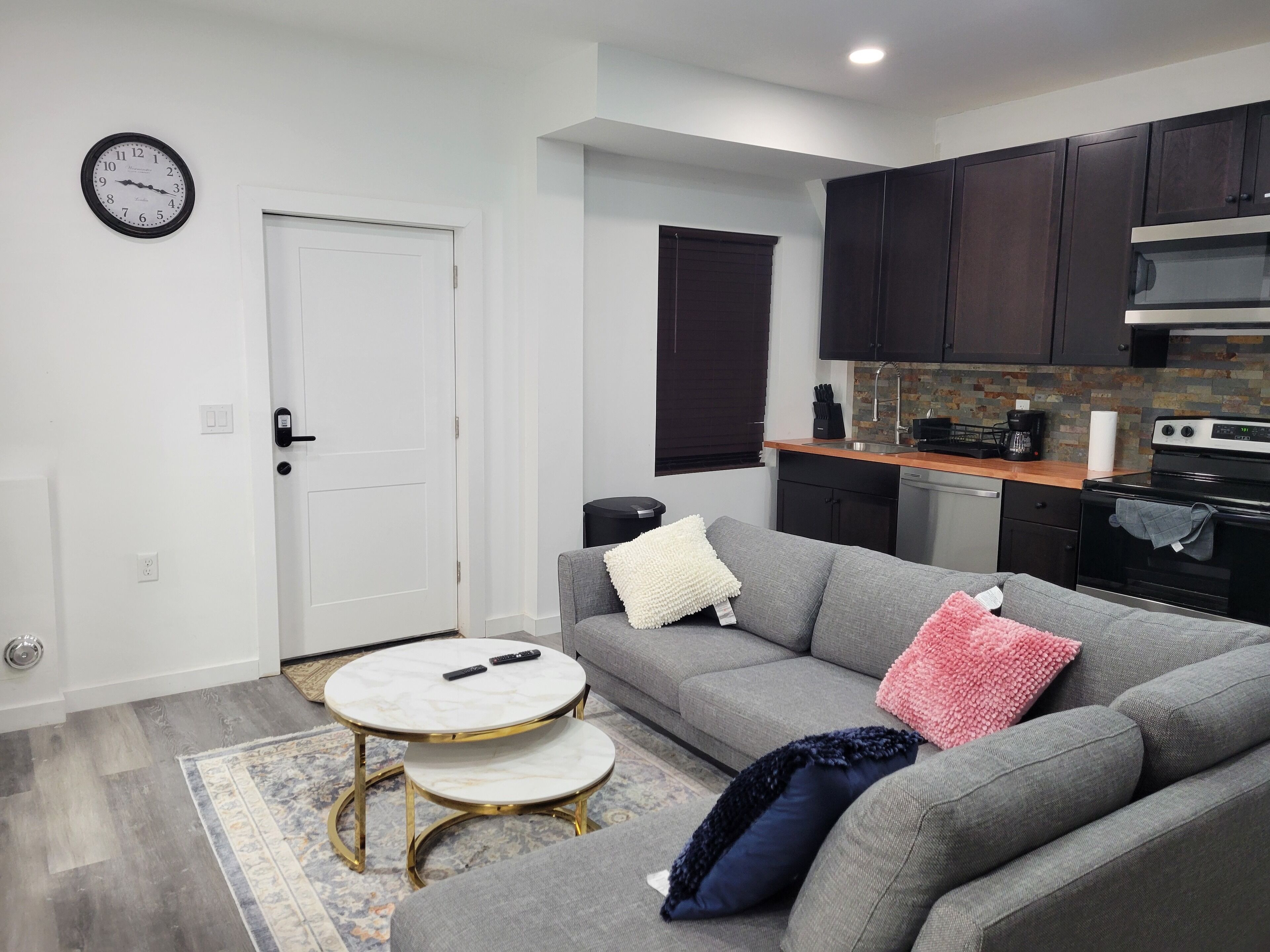 A modern living room with a gray sofa, a small round table, and a white door.