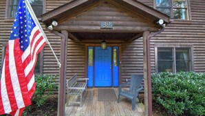 Une cabane en bois avec une porte bleue, le numéro 82, et un drapeau américain.
