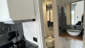 Eine moderne Küche mit schwarzem Arbeitsplatz und einer Spüle aus Edelstahl.