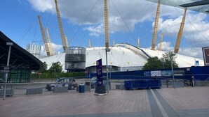 A stadium with a large white roof and multiple tall cranes.