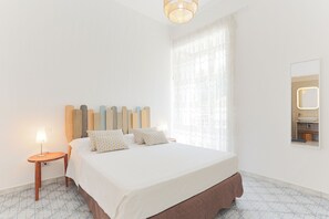 Restful retreat with a large bed, nightstand, and mirror.