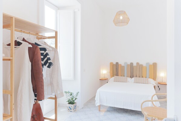 Relax in a serene bedroom with a comfortable bed, a stylish wardrobe, and a bedside table with a lamp.
