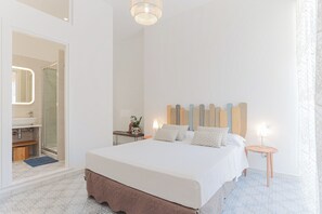 Relax in a spacious bedroom with a large bed, bedside tables, and a mirror.