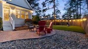 A house with a patio area featuring outdoor furniture and a wooden fence. - Relaxing home w/ putting green 5 min to Pinehurst (Pinehurst)