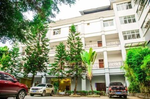 Un edificio de varios pisos con una zona de estacionamiento al frente.