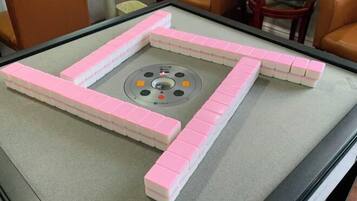 A table with a game board and pink game pieces.