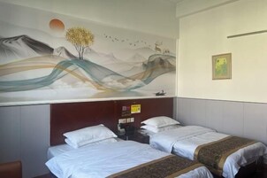 Una habitación de hotel con dos camas, un mural en la pared y un cuadro pequeño sobre la cama.