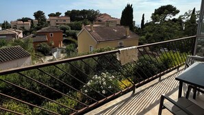 A balcony with a view of residential buildings, greenery, and a clear sky. - T2 Coloré Proche mer - Parking / Terrasse / 2 Lits 160x200 (Six-Fours-les-Plages)