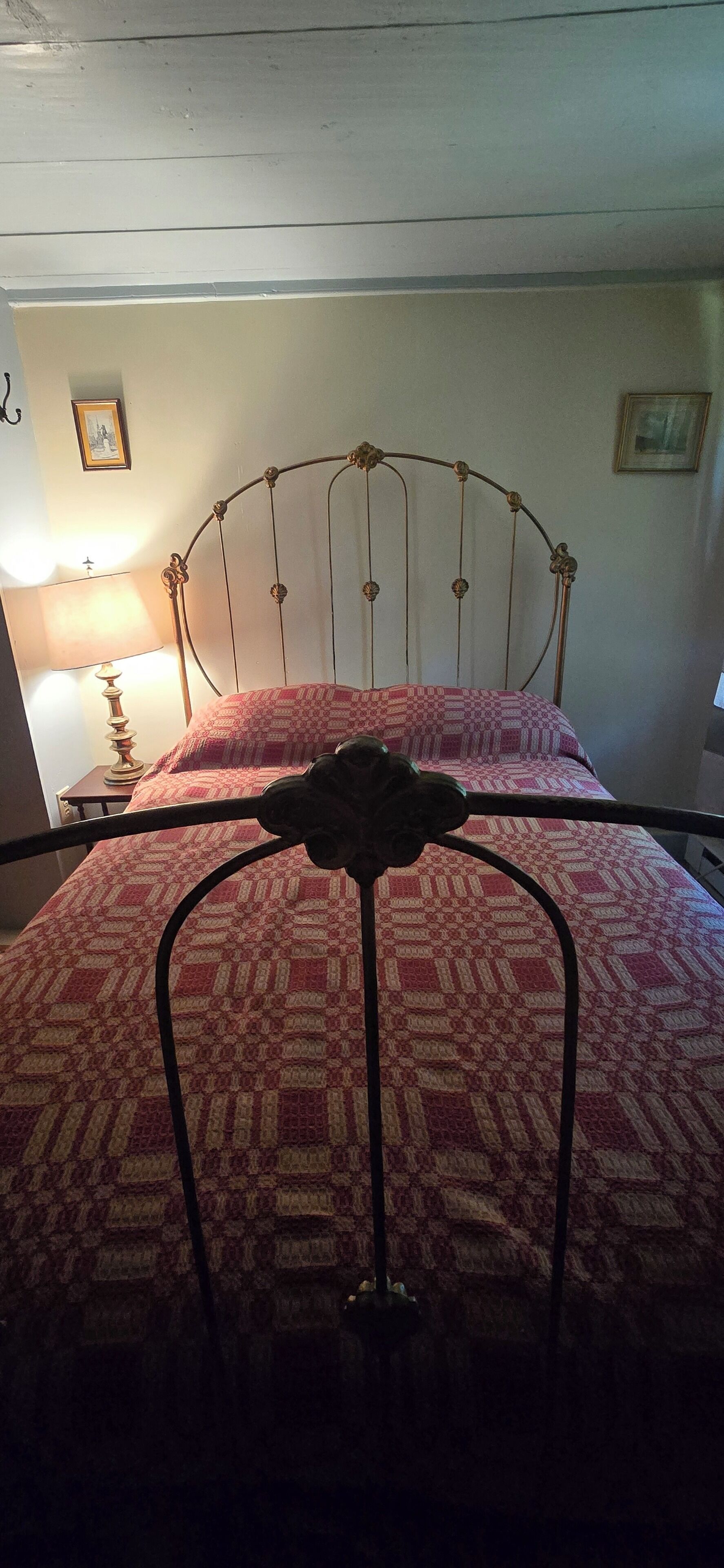 A bed with a metal frame and a patterned bedspread.