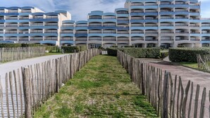 Un hôtel moderne à plusieurs étages, doté d’une cour intérieure et entouré d’une clôture en bois.