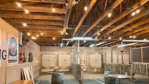 An indoor shooting range with wooden beams, targets, and shooting booths.