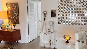 Ein modernes Wohnzimmer mit einem weißen Sofa, einem Couchtisch und einer Wand mit dekorativen Rundspiegeln.