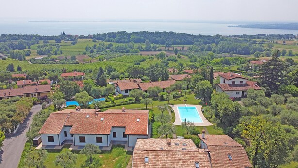 Un quartier résidentiel avec des maisons à étages, une piscine et une vue sur la mer.
