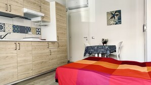A compact kitchen with wooden cabinets, a white countertop, and a tiled backsplash. - M406 - Marcelli, new studio apartment facing the sea (Marcelli)