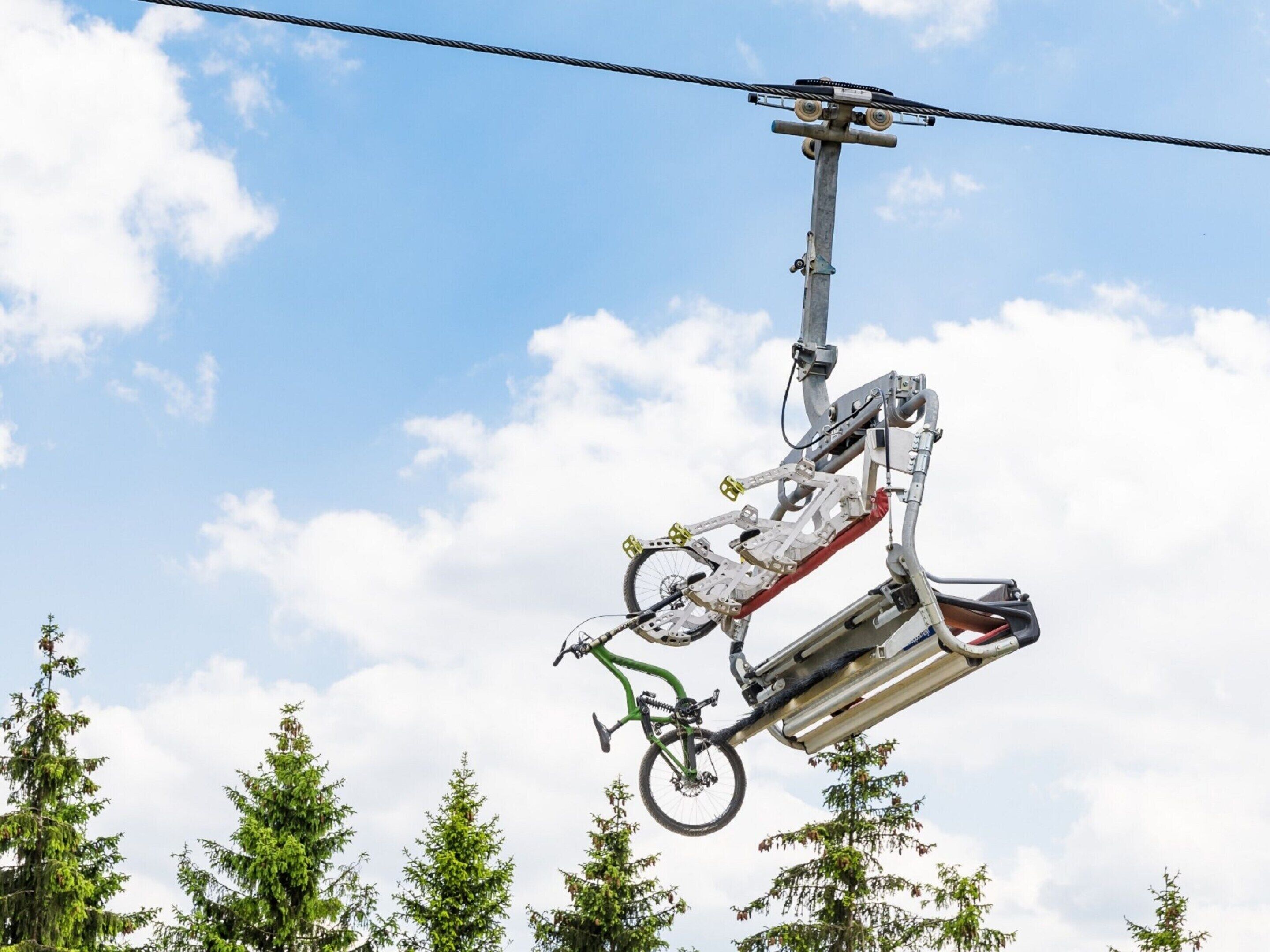 A cable car system with a bicycle suspended in the middle.
