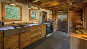 A kitchen with wooden cabinets, a stainless steel refrigerator, and a large window.