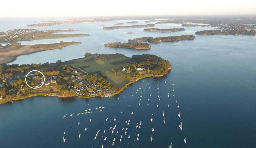 Une vue aérienne d’une zone côtière comprenant de nombreuses îles, une marina avec de nombreux bateaux, et une zone encerclée indiquant un lieu précis.