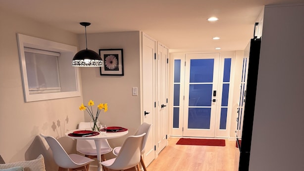 A modern living room with a sofa, a coffee table, and a dining area with chairs and a table.