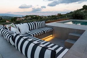 Un espace extérieur moderne, aménagé avec des sièges et une piscine, offrant une vue imprenable sur un paysage magnifique.