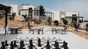 A chessboard set up outdoors with modern buildings in the background.