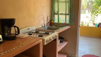 Een koelkast, een vaatwasser, kookgerei, borden en bestek