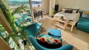 Ein modernes Hotelzimmer mit Balkon, einem Bett, einem Schreibtisch und zwei Stühlen.