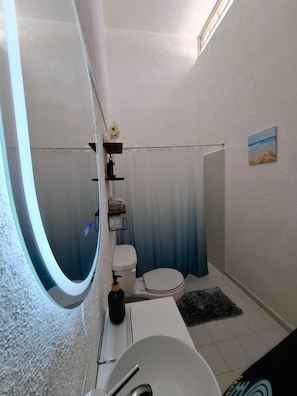 Un bagno con servizi igienici, lavandino e tenda della doccia.