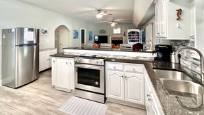 A modern kitchen with stainless steel appliances, white cabinetry, a granite countertop, and a built-in oven. - HUGE % OFF, Private Pool ☀️ Walk to Beach, Screened Porch, 6 Bdrm ☀️ Big Driveway (Seagrove Beach)