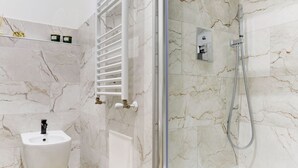 A bathroom with a marble floor, a white pedestal sink, a glass-enclosed shower, and a towel rack. - SAN GIOVANNI COZY APT - HOME AND MORE (Roma)