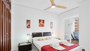 A hotel room with a bed, nightstands, a ceiling fan, artwork on the wall, and a view of the outside. - Ref. 493702 (Almuñecar)