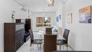 A modern dining area with a glass table, brown chairs, a dark wooden cabinet, and artwork on the walls. - Ref. 493702 (Almuñecar)