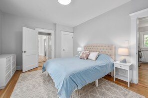 A bedroom with a bed, bedside tables, a wardrobe, and an open door leading to another room. - Your Cape State of Mind Adventure Awaits! (South Yarmouth)