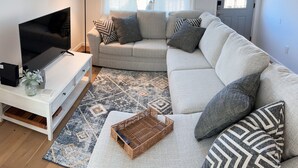 Un salon avec un téléviseur, un canapé et une lampe.