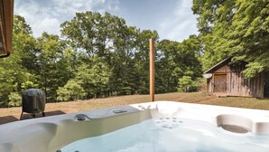 A hot tub with a wooden structure in the background. - Redhead Hollow Cottage | Hocking Hills, Hot Tub (Rockbridge)