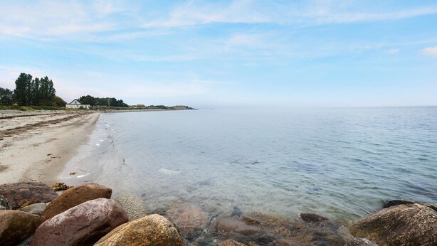 A beach with clear water, rocks in the foreground, and a house on the left. - Awesome home in Korsør with WiFi (Korsør)