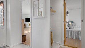 A modern, white-walled room with a bed, a television, and a small table with a chair. - Awesome home in Korsør with WiFi (Korsør)