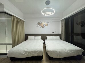 Una habitación de hotel moderna con dos camas, un ventanal con cortinas, una lámpara fijada a la pared y una obra de arte decorativa.