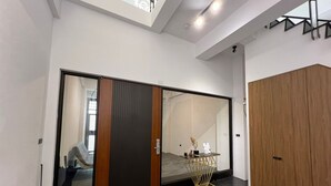 Un intérieur moderne avec une porte coulissante, une armoire en bois et une petite table agrémentée d’objets décoratifs.