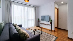 A modern living room with a sofa, coffee table, and TV. - Llanes Celorio Swimming Pool and Beach - El Castro Borizu (Celorio (Llanes))
