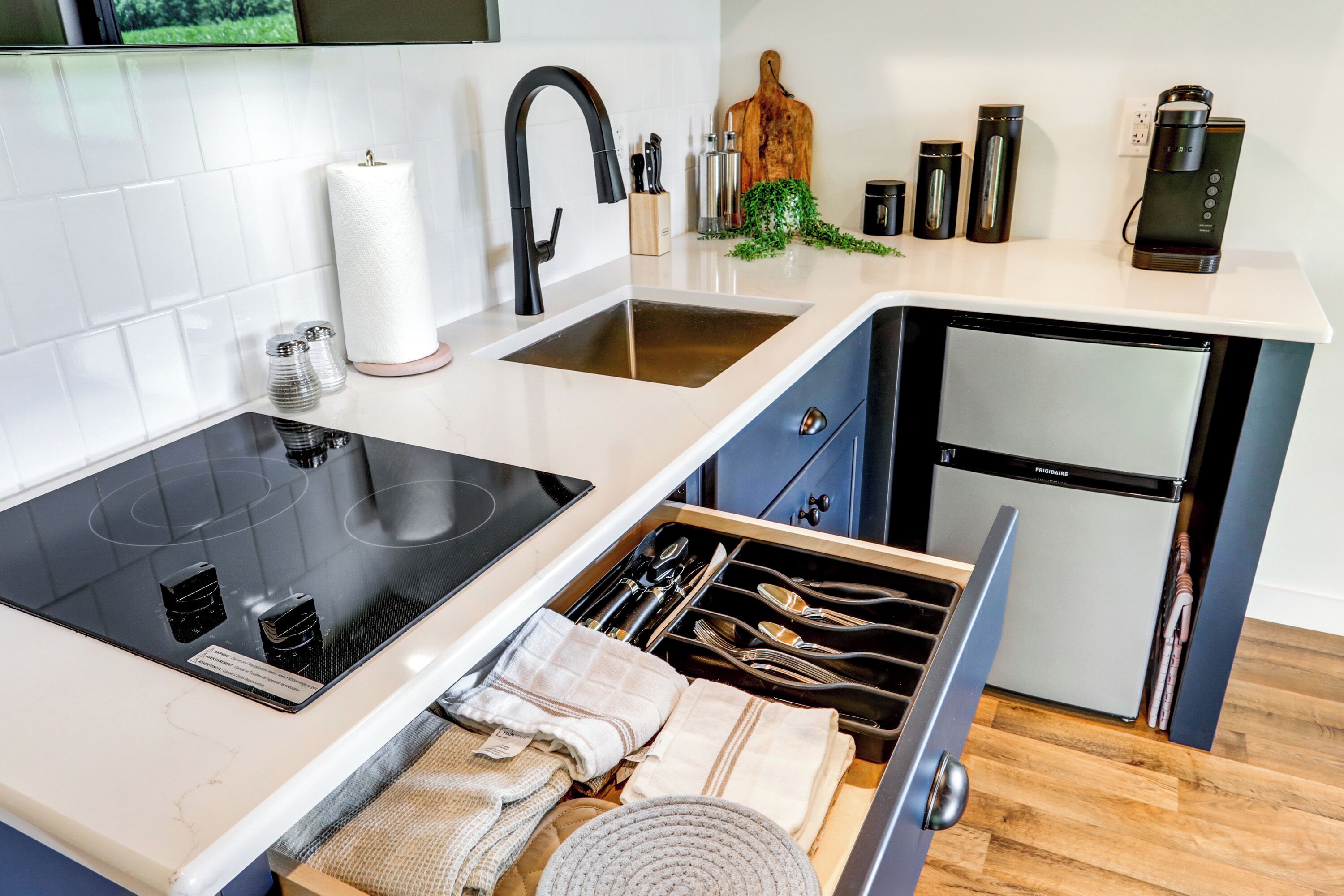 A modern kitchen with a built-in stove, a sink, and a refrigerator.