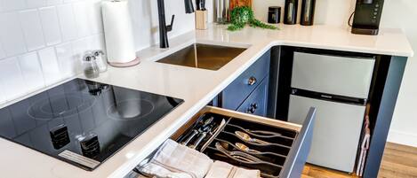 A modern kitchen with a built-in stove, a sink, and a refrigerator.