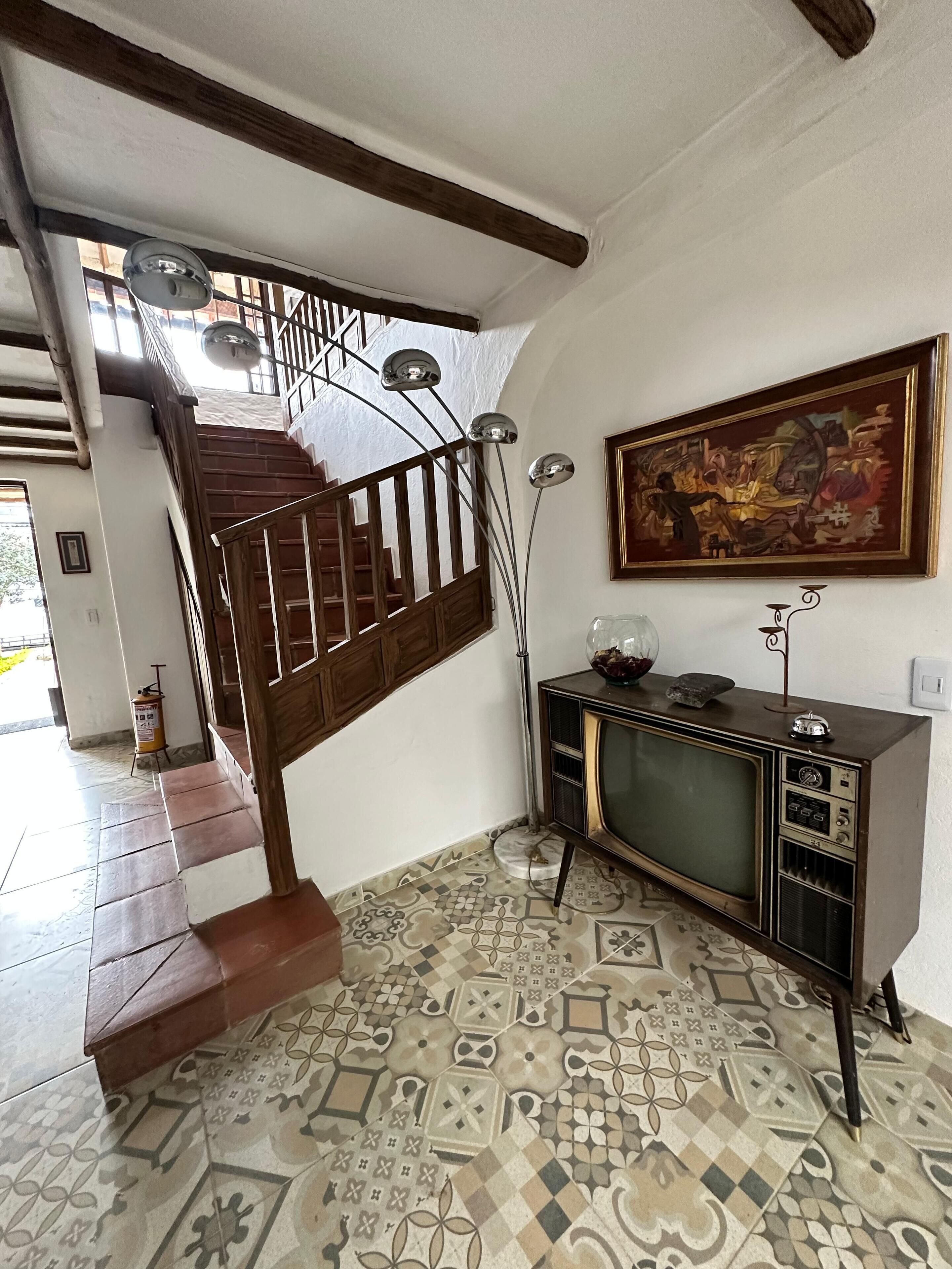 Una escalera con barandillas de madera y piso estampado.