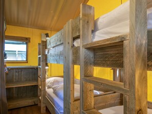 Dormitorio con literas de madera y ropa de cama blanca.