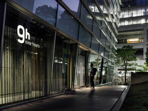 A modern building with large glass windows and a sign indicating '9h nine hours'. - 9h nine hours Shinagawa station for men (Tokyo)