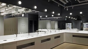 Une salle de bain moderne dotée de plusieurs lavabos, de miroirs et d’armoires de rangement.