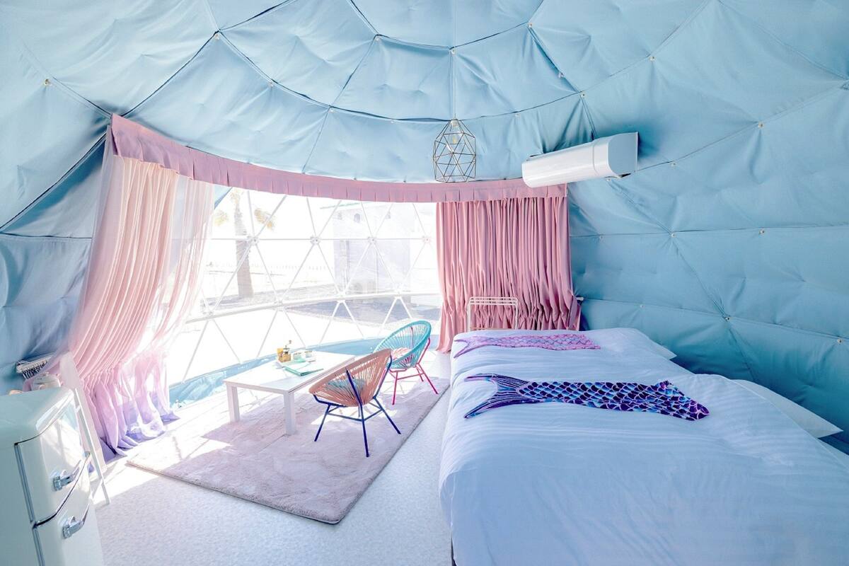 A cozy bedroom with a bed, a chair, and a desk.