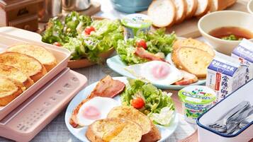 Een ontbijtsetting met toast, eieren, spek, salade en toevoegingen op een tafel.